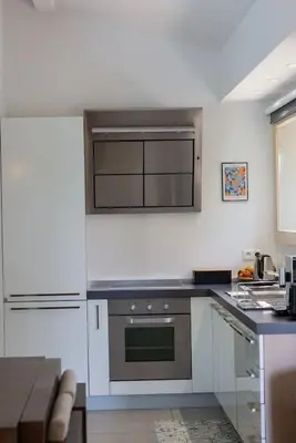 a kitchen with white cabinets and a stove top oven at Les Hameaux De Buttaciolo in Cuo