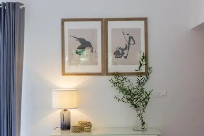 a table with a lamp and three pictures on the wall at Les Hameaux De Buttaciolo in Cuo