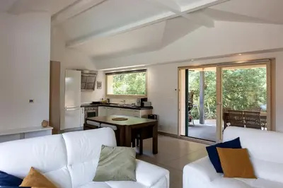 a living room with a white couch and a kitchen at Les Hameaux De Buttaciolo in Cuo