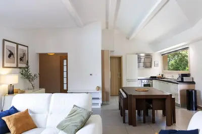 a living room with a white couch and a table at Les Hameaux De Buttaciolo in Cuo