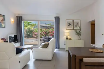 a living room with two white chairs and a table at Les Hameaux De Buttaciolo in Cuo