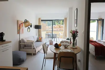 a white living room with a table and a living room at Filori - T2 avec piscine chauffée et plage privée in Pianottoli-Caldarello