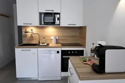 a kitchen with a sink and a microwave at Filori - T2 avec piscine chauffée et plage privée in Pianottoli-Caldarello