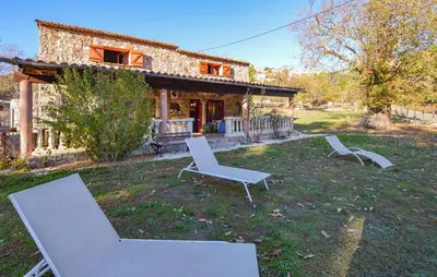 two chairs and a table in front of a house at Grande Villa Piscine in Evisa