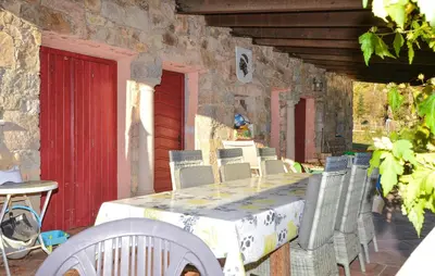 a table and chairs on a patio with a red door at Grande Villa Piscine in Evisa