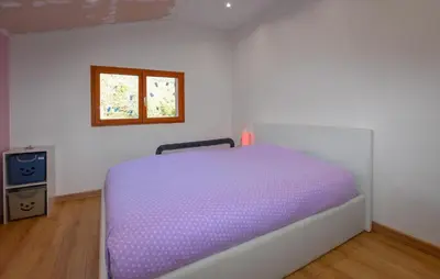 a purple bed in a room with a window at Grande Villa Piscine in Evisa