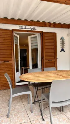 a wooden table and chairs in front of a building at La villa Emmagathe in Poggio-Mezzana