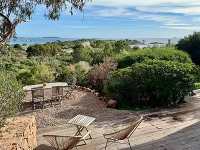 a patio with two chairs and a table and chairs at Casetta di Asciaghju, suite avec jacuzzi privé et accès direct aux plages in Porto-Vecchio