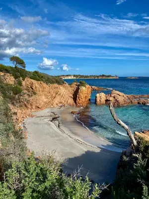 a beach with sand and the water and rocks at Casetta di Asciaghju, suite avec jacuzzi privé et accès direct aux plages in Porto-Vecchio