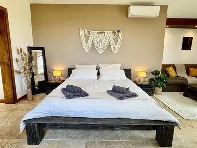 a bedroom with a large bed with two pillows on it at Casetta di Asciaghju, suite avec jacuzzi privé et accès direct aux plages in Porto-Vecchio