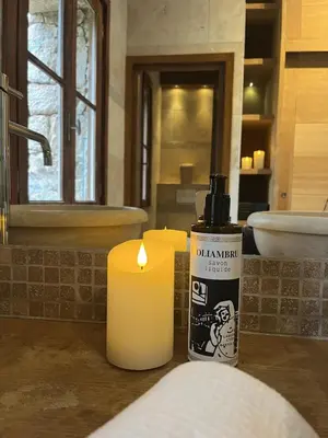 a bathroom with two candles and a mirror and a sink at Casetta di Asciaghju, suite avec jacuzzi privé et accès direct aux plages in Porto-Vecchio