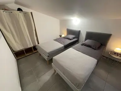 a room with two beds and a table with a mirror at Mini Villa - Les Hameaux de Saint Cyprien in Lecci