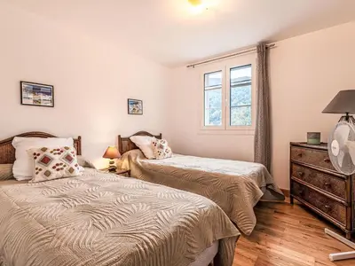 a bedroom with two beds and a window at Maison entre mer et montagne in Santa-Reparata-di-Moriani