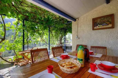 a wooden table with a basket of food on it at Maison entre mer et montagne in Santa-Reparata-di-Moriani