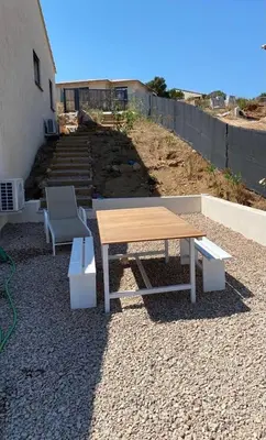 a picnic table and a chair on a gravel patio at Casa Gioia Maisonette à Sotta in Sotta