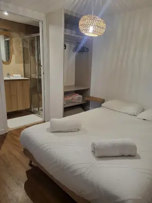 a bedroom with a large bed and a chandelier at Casa Gioia Maisonette à Sotta in Sotta