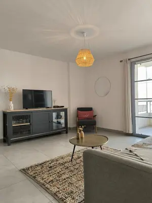 a living room with a couch and a tv at Port de Bonifacio in Bonifacio