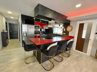 a kitchen with a red counter top and black cabinets at Villa avec piscine 8 personnes in Porto-Vecchio