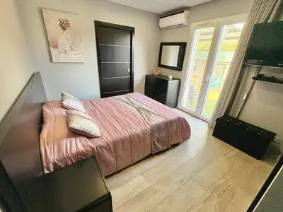 a bedroom with a bed and a television in it at Villa avec piscine 8 personnes in Porto-Vecchio