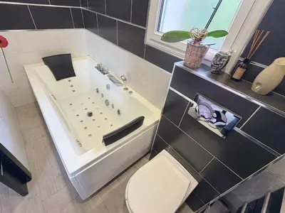 a bathroom with a bath tub and a toilet at Villa avec piscine 8 personnes in Porto-Vecchio