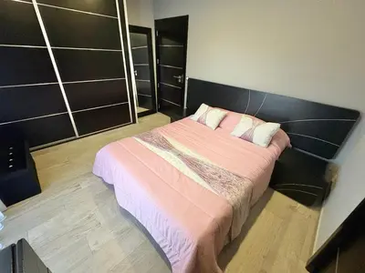 a bedroom with a bed with pink sheets and pillows at Villa avec piscine 8 personnes in Porto-Vecchio