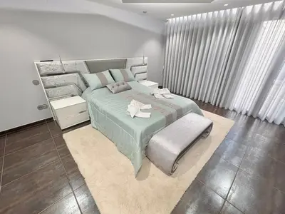 a bedroom with a large bed and a chair at Villa avec piscine 8 personnes in Porto-Vecchio