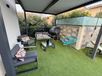 a patio with chairs and a table and a grill at Villa avec piscine 8 personnes in Porto-Vecchio