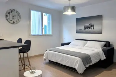a bedroom with a bed and a clock on the wall at Studio climatisé au cœur d Ajaccio - à pied des plages et du centre in Ajaccio