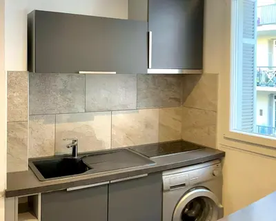a kitchen with a sink and a washing machine at Studio climatisé au cœur d Ajaccio - à pied des plages et du centre in Ajaccio