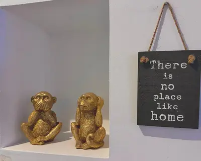 two gold monkeys sitting on a shelf next to a sign at Studio climatisé au cœur d Ajaccio - à pied des plages et du centre in Ajaccio