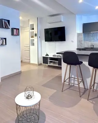 a living room with a kitchen and a table and chairs at Studio climatisé au cœur d Ajaccio - à pied des plages et du centre in Ajaccio