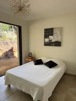 a bedroom with a large white bed with a chandelier at Casa di u Fiume in Peri