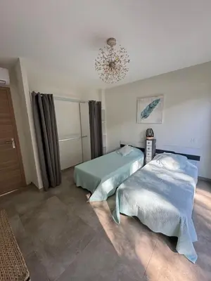 a bedroom with two beds and a chandelier at Casa di u Fiume in Peri