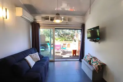 a living room with a blue couch and a sliding glass door at Bright apartment with terrace near the beach in Calcatoggio