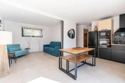a kitchen and living room with a blue couch and a table at Villa U Veniqui 1 - Piscine privée in Conca