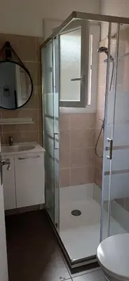 a bathroom with a shower and a toilet and a sink at Mini villa 200 mètres de la plage de Santa Guilia in Porto-Vecchio