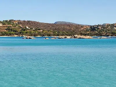 a large body of water with a town in the background at Mini villa 200 mètres de la plage de Santa Guilia in Porto-Vecchio
