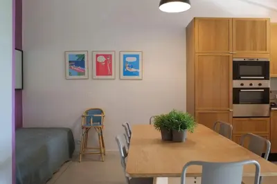 a living room with a table and a kitchen at Mini Villa Santa in Porto-Vecchio