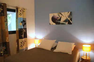 a bedroom with a bed with two lamps on it at Mini Villa Santa in Porto-Vecchio