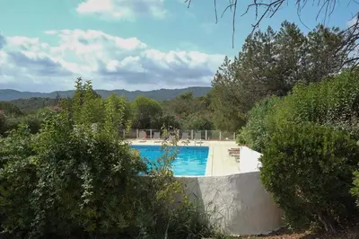 a swimming pool in the middle of a yard with trees at Mini Villa Santa in Porto-Vecchio