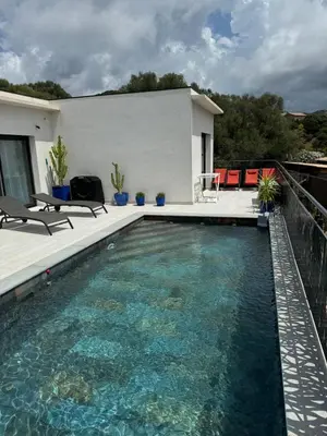 a swimming pool in front of a house at magnifique villa au calme avec superbe piscine in Figari