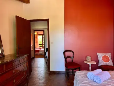 a bedroom with a bed and a table and a chair at Villa Caline, 4 chambres, lotissement calme et proche mer in Lucciana