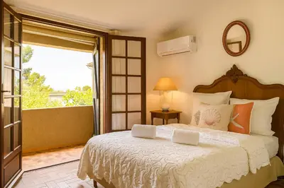 a bedroom with a large bed and a window at Villa Caline, 4 chambres, lotissement calme et proche mer in Lucciana