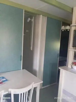 a kitchen with a white table and a door at Bungalow charmant à Sorbo-Ocagnano avec jardin in Sorbo-Ocagnano