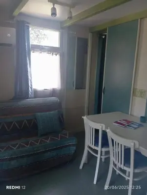 a room with a table and a bed and a table and chairs at Bungalow charmant à Sorbo-Ocagnano avec jardin in Sorbo-Ocagnano