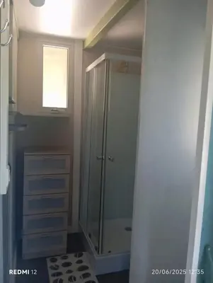 a bathroom with a shower and a glass door at Bungalow charmant à Sorbo-Ocagnano avec jardin in Sorbo-Ocagnano