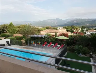 a villa with a swimming pool and mountains in the background at Villa les Palmiers pool spa view of Bavella in Sainte-Lucie de Porto-Vecchio