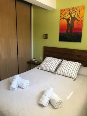 a bedroom with a bed with two towels on it at Villa les Palmiers pool spa view of Bavella in Sainte-Lucie de Porto-Vecchio