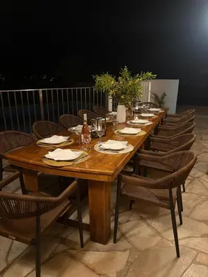 a long wooden table with chairs around it at Villa les Palmiers pool spa view of Bavella in Sainte-Lucie de Porto-Vecchio