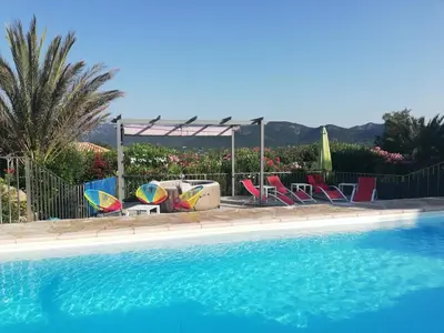 a group of chairs and a swimming pool at Villa les Palmiers pool spa view of Bavella in Sainte-Lucie de Porto-Vecchio